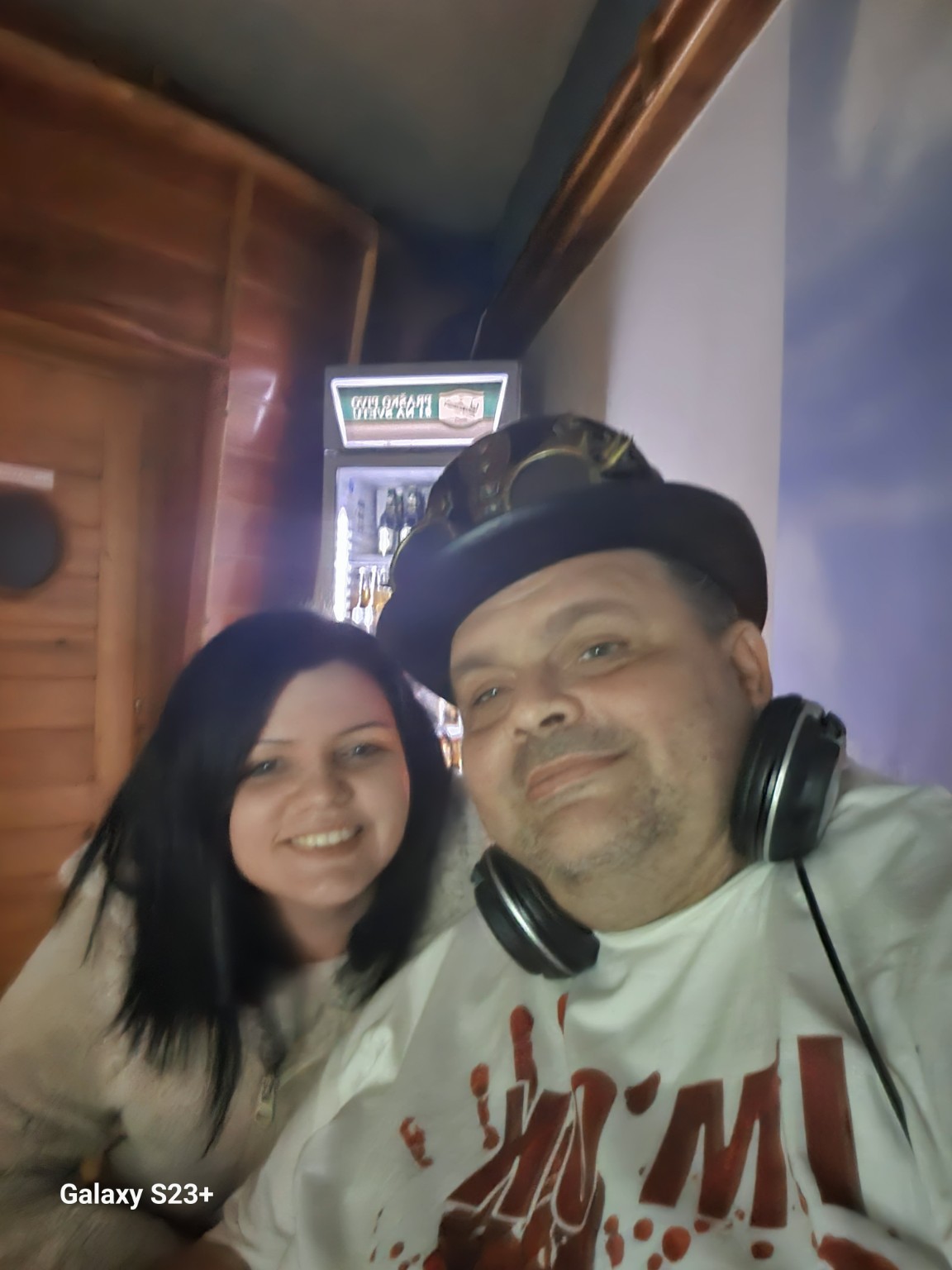 Nasmejana družba na dogodku, DJ s slušalkami in klobukom