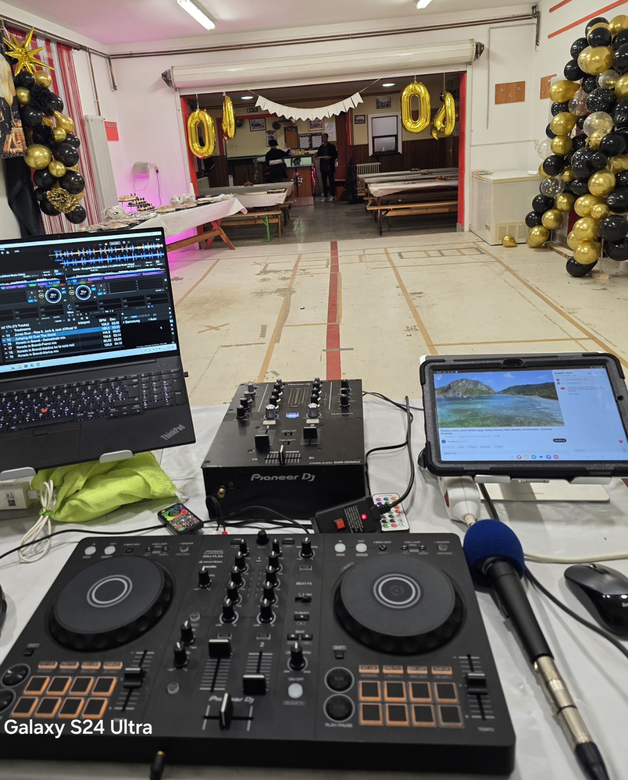 DJ oprema, mikrofon in okrašena dvorana, pripravljena na praznovanje